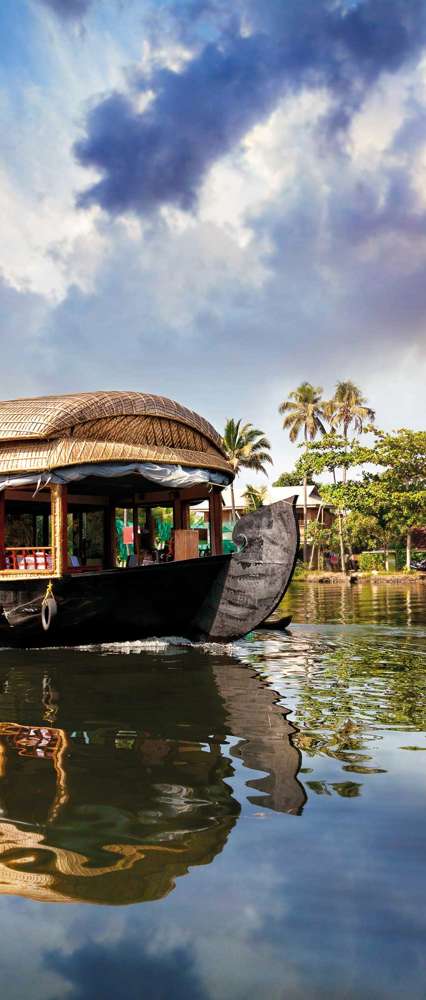 House Boat In Backwaters Near Palms At Cloudy Blue Sky In Alappuzha Kerala, India
