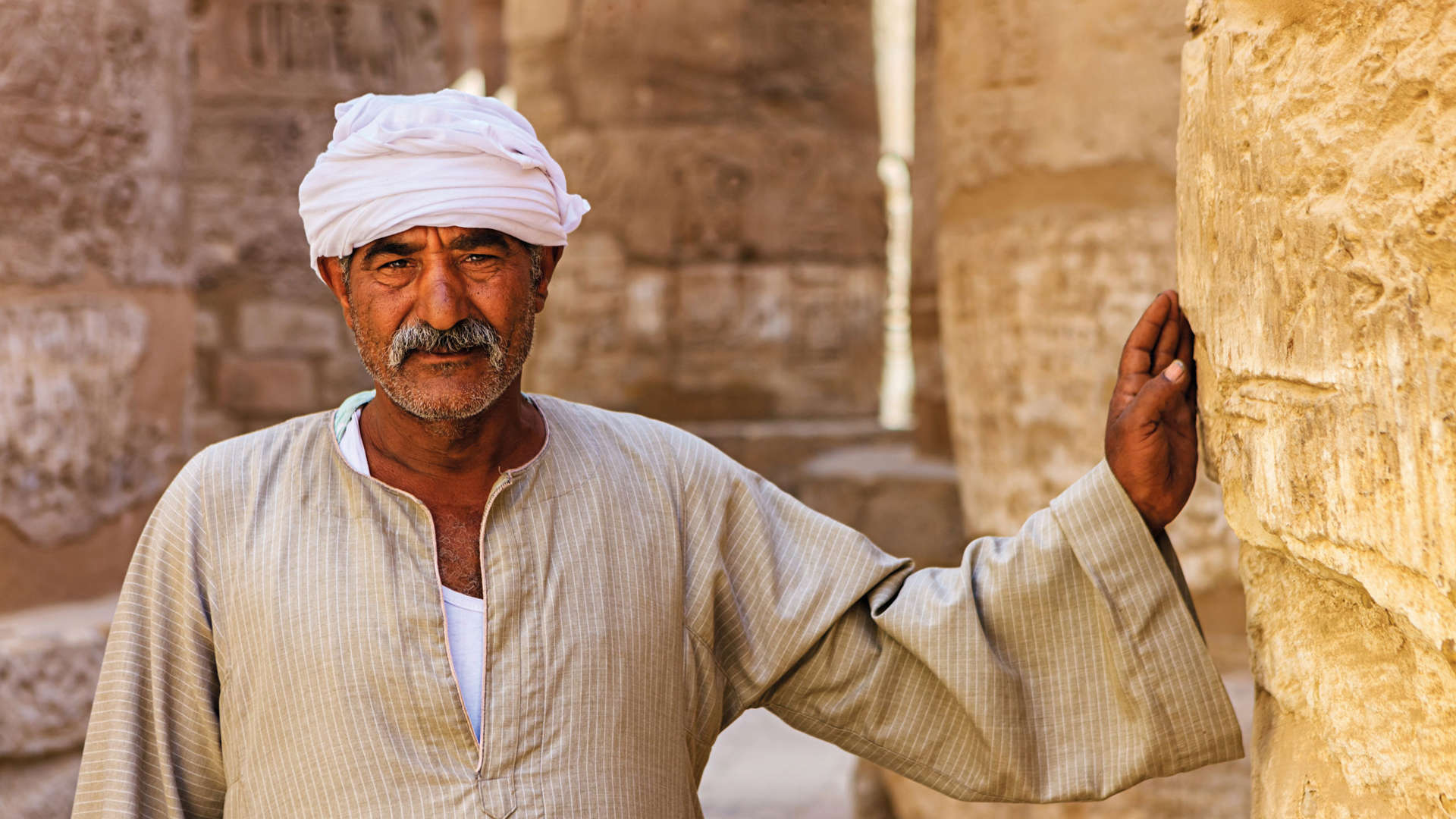 Man leaning on Karnak Temple, Egypt
