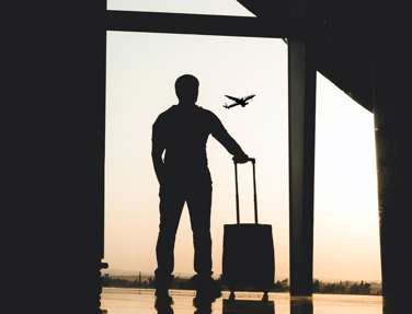 Man standing in airport watching plane leave
