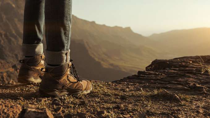 Man wearing walking boots on a low rocky cliff